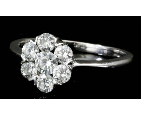 A Seven Stone Diamond Ring, Modern, in 18ct white gold mount, of flowerhead pattern, set with round brilliant cut diamonds, a