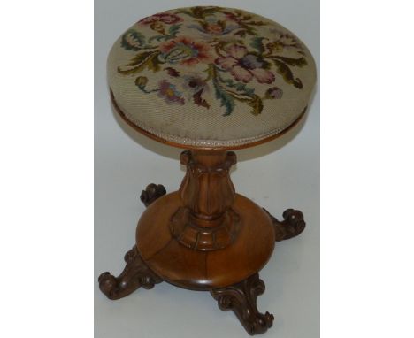 A small Victorian rosewood revolving piano stoolWith tapestry seat, turned column and four scroll feet, diameter of top 35cm.