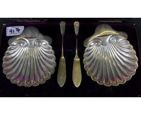 A Victorian pair of silver butter dishes and matched knivesDesigned as shells raised on three ball feet, cased, the butter di