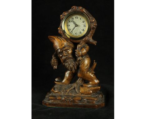 An early 20th Century Black Forest carved wooden mantle clockModelled in the form of a gnome supporting a circular silvered d