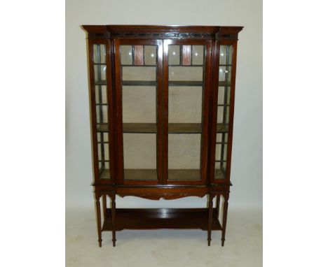 An Edwardian mahogany breakfront display cabinet Fitted with moulded cornice over two panelled doors over a base shelf, raise