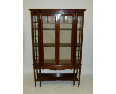 An Edwardian mahogany breakfront display cabinet Fitted with moulded cornice over two panelled doors over a base shelf, raise