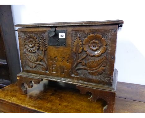 AN OAK COFFER WITH THE FRONT CARVED WITH TWO FLOWER STEMS FLANKING 1671 AND E P ABOVE WAVY BRACKET FEET. W 57 x D 34 x H 42cm