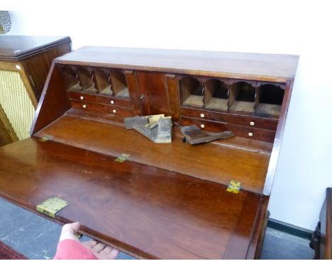 A GEORGE III MAHOGANY BUREAU, THE FALL ENCLOSING PIGEON HOLES AND DRAWERS FLANKING THE CENTRAL CUPBOARD ABOVE FOUR GRADED LON
