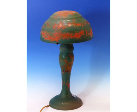 A CAMEO ART GLASS TABLE LAMP AND SHADE ETCHED THROUGH GREEN AND BRIGHT RED THROUGH TO AMBER WITH TREES GROWING BY WATER. INCI