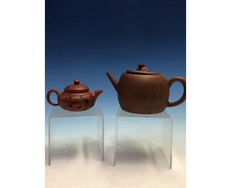 A YIXING TEA POT, THE COVER WITH RECLINING LION FINIAL TOGETHER WITH ANOTHER SMALLER INCISED WITH A DRAGON