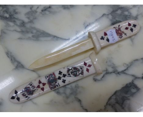 A BONE PAPER KNIFE AND SCABBARD DECORATED WITH PLAYING CARDS AND THEIR SUITS.   W 27cms.