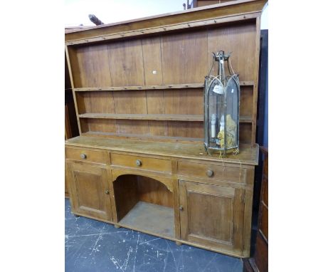 A 19th C. PINE DRESSER, THE ENCLOSED TWO SHELF BACK RECESSED ABOVE A BASE WITH A CENTRAL DRAWER OVER A NICHE FLANKED BY DRAWE