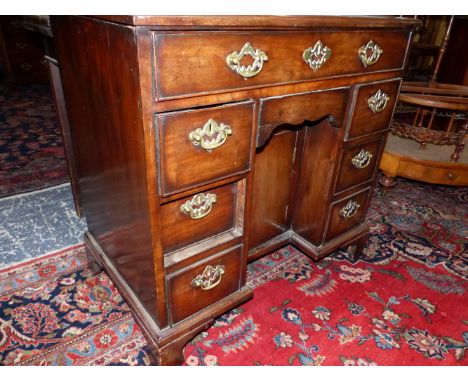A GEORGE III AND LATER&nbsp; MAHOGANY KNEEHOLE DESK WITH A LONG DRAWER OVER THE CENTRAL RECESSED CUPBOARD FLANKED BY THREE DR