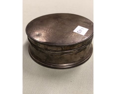 AN ENGINE TURNED SILVER FACE POWDER CYLINDRICAL BOX, INDISTINCT MARKS, A MIRROR INSIDE THE ENGINE TURNED LID CONTAINING COINS