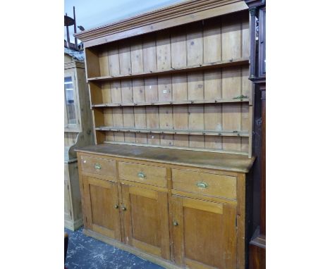 AN ANTIQUE PINE DRESSER, THE ENCLOSED THREE SHELF BACK RECESSED ABOVE THREE DRAWERS AND THREE CUPBOARDS ON A PLINTH FOOT. W 1