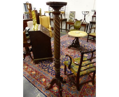 A MAHOGANY TRIPOD TORCHERE, THE DISHED CIRCULAR TOP ON A SPIRAL TURNED COLUMN, LEAVES CARVED AT THE KNEES OF THE LEGS ON PAW 