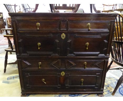 AN 18th C. OAK CHEST OF TWO SHORT AND THREE LONG DRAWERS WITH GEOMETRICALLY PANELLED FRONTS AND ON BRACKET FEET.   W 104 x D 