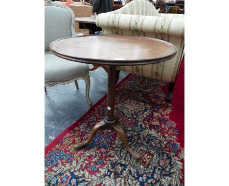 A GEORGIAN MAHOGANY TRIPOD TABLE, THE DISHED CIRCULAR TOP ON GUN BARREL COLUMN ABOVE CLUB FEET.   Dia. 57 x H 66cms.