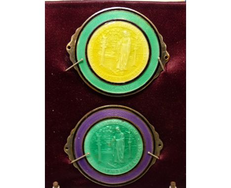 TWO BASSE TAILLE ENAMEL ROUNDELS OF ST BARTHOLOMEW MOUNTED ON PURPLE SILK WITHIN A FRAME.   12 x 12cms.