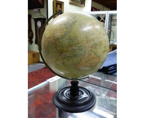 A PHILIPS 12 INCH TERRESTIAL GLOBE SPINNING WITHIN A CHROME ARC ON AN EBONISED WOOD PLINTH