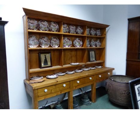A PINE DRESSER, THE ENCLOSED BACK WITH THREE BANKS OF THREE SHELVES RECESSED ABOVE THREE DRAWERS WITH WHITE CERAMIC KNOB HAND