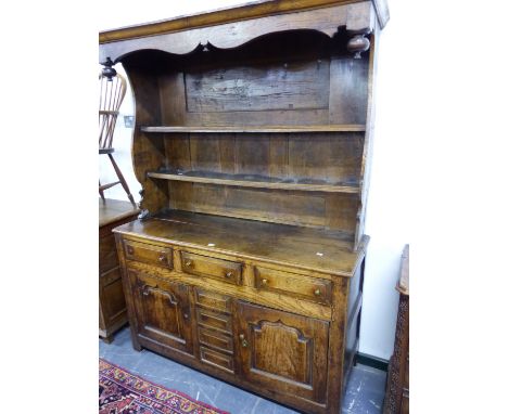 A 19thC. OAK DRESSER, A HOOD RAISED OVER THE ENCLOSED TWO SHELF BACK, THE BASE WITH THREE DRAWERS OVER TWO DOORS.   W 136 x D