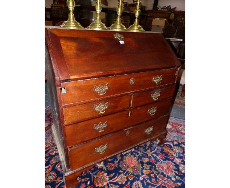 A GEORGE III MAHOGANY BUREAU, THE FALL OPENING ONTO PIGEON HOLES, DRAWERS AND A SLIDE CONCEALED COMPARTMENT, TWO SHORT AND TW