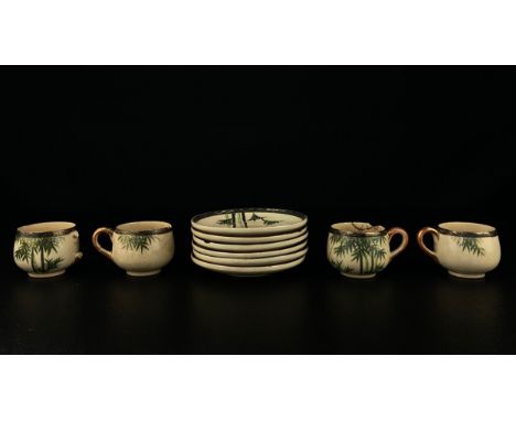 A part set of early 20th century Japanese possibly Meiji Satsuma porcelain cups and saucers with hand painted bamboo decorati