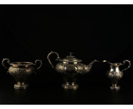 A 19th century Scottish hallmarked silver three piece tea set with all-over scrolling foliate repousse decoration and central