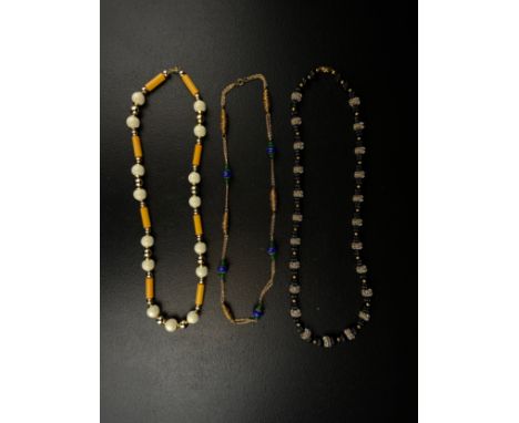 A collection of three necklaces to include a vintage Christian Dior gold plated metal mounted bakelite necklace with Chr. Dio