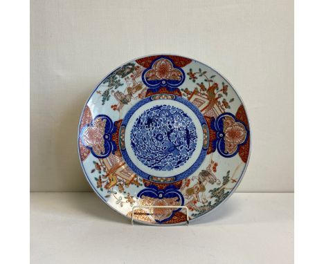 A large Japanese Edo period Imari porcelain charger having a central hand painted cartouche bearing a five clawed Imperial dr
