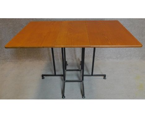 A vintage teak folding table with gateleg action on metal base. 73x123x78cm 