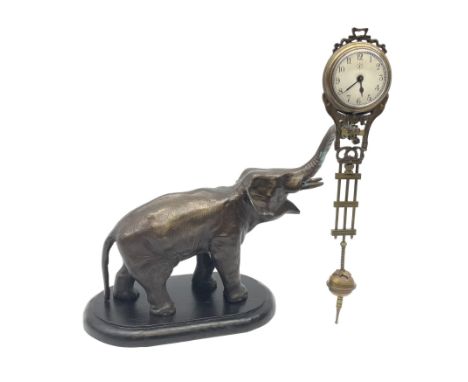 A spelter mystery clock modelled as an elephant supporting the clock upon its trunk, the white circular dial with black Arabi