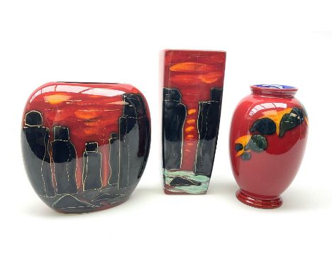 A Poole Pottery vase, of ovoid form decorated with green and yellow forms upon a red glazed ground, H20cm, together with two 