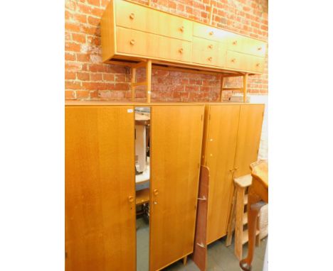 A vintage bedroom suite, comprising dressing table and two wardrobes, one with mirrored centre.