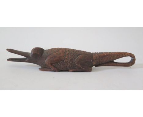 A 19th Century Naive Treen Nut Cracker in the form of a crocodile with hole to the underside and screw on tail, 22cm 