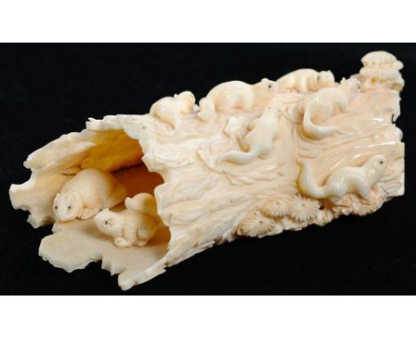 A JAPANESE NATURALISTIC IVORY CARVING OF A DECAYED TREE TRUNK INHABITED BY A FAMILY OF NINE SQUIRRELS, 10CM L, MEIJI PERIOD 