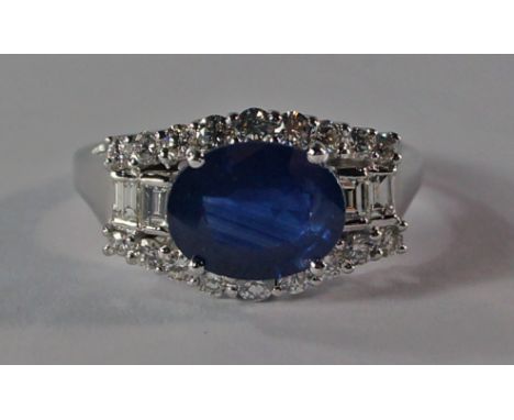 A 14ct white gold, sapphire and diamond ring, the 3.10ct oval cut sapphire flanked by baguette diamonds and lines of brillian