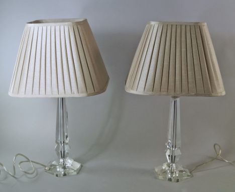 A pair of faceted glass lamp bases, 20th century, together with square pleated material shades, 28.6cm high(2)(It is the buye