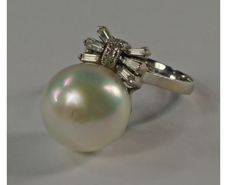 A single pearl and diamond set ring, the large pearl with a stylized bow of baguette cut diamonds, mounted in 14ct white gold