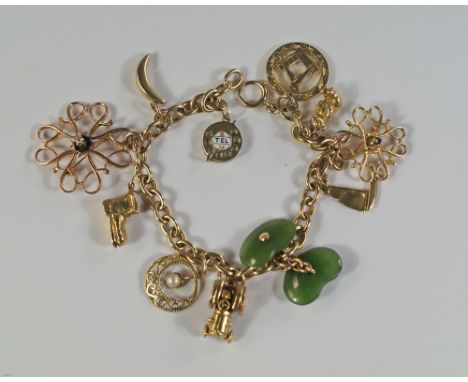 A 9ct gold charm bracelet hung with various charm, including a tractor, boot, telephone dial, a diamond set brooch, and a 15c