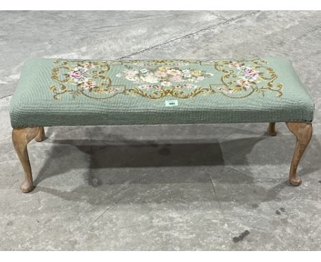 A stool with tapestry seat on cabriole legs. 36" wide.