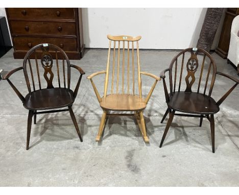 An Ercol blonde rocking chair and a pair of armchairs.