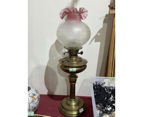 A brass oil lamp with duplex burner and ruby flashed etched shade. 26" high