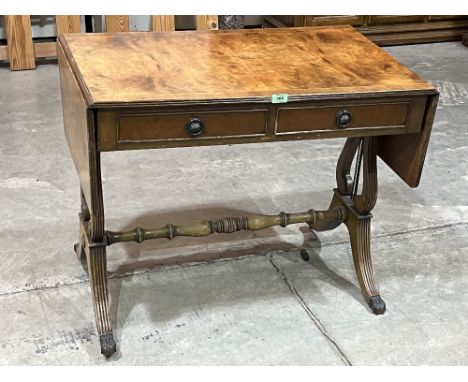 A walnut sofa table on lyre trestle supports.