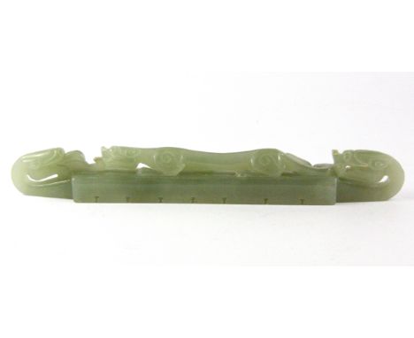 A 19th/ early 20th Century Chinese carved nephrite jade brush rest decorated with a dragon and dragon and phoenix heads, L. 1