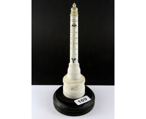 A 19th Century carved ivory thermometer on a carved wooden base, H. 26cm.