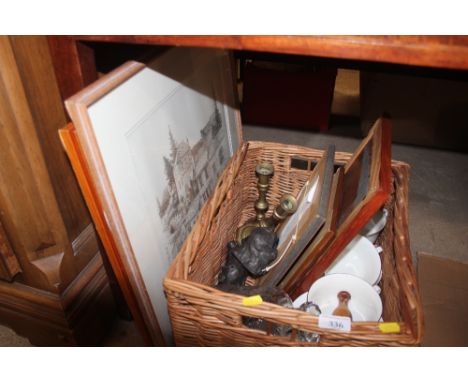 A basket containing a pair of Victorian brass candle sticks; various prints; a decanter etc