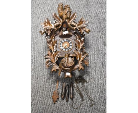 A traditional cuckoo style clock having additional owl decoration and revolving mechanism