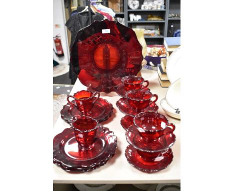 A collection of mid century ruby glass cups and saucers, plates and sugar basin.