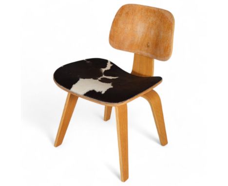 An Eames LCW style chair with oak veneer bent ply and cowhide seat, no maker's mark, height 74cmThe backrest veneer top layer