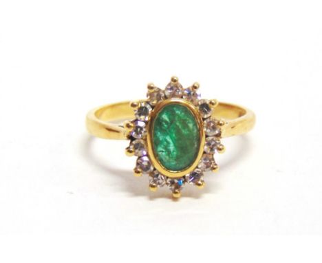 AN EMERALD AND DIAMOND 18 CARAT GOLD CLUSTER RING the oval cut stone enclosed by seven single cut diamonds, finger size R, 4g