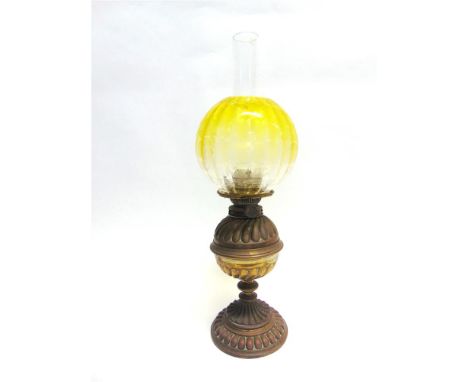AN EDWARDIAN OIL LAMP with decorative embossed brass base, the coloured glass shade with acid etched foliate decoration, 58.5