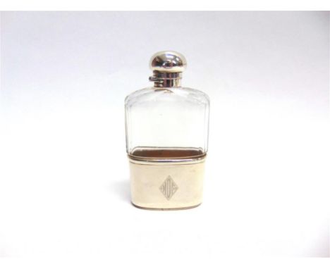 A SILVER MOUNTED GLASS HIP FLASK Mappin & Webb, London 1921, with captive bayonet caps, and monogrammed pull off base